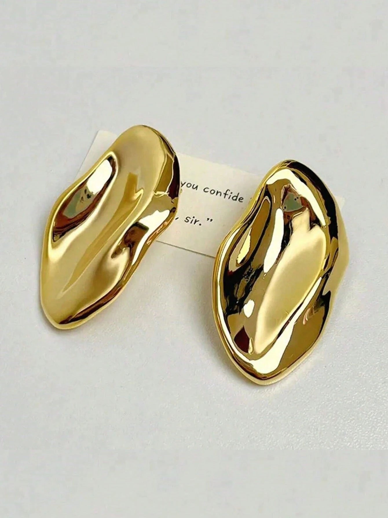 Gold sculpted earrings close-up view