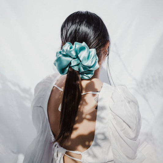 Model wearing extra large satin scrunchie in teal – handmade in Cape Town
