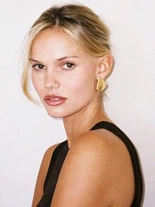Model wearing gold geometric stainless steel stud earrings – bold fashion jewellery