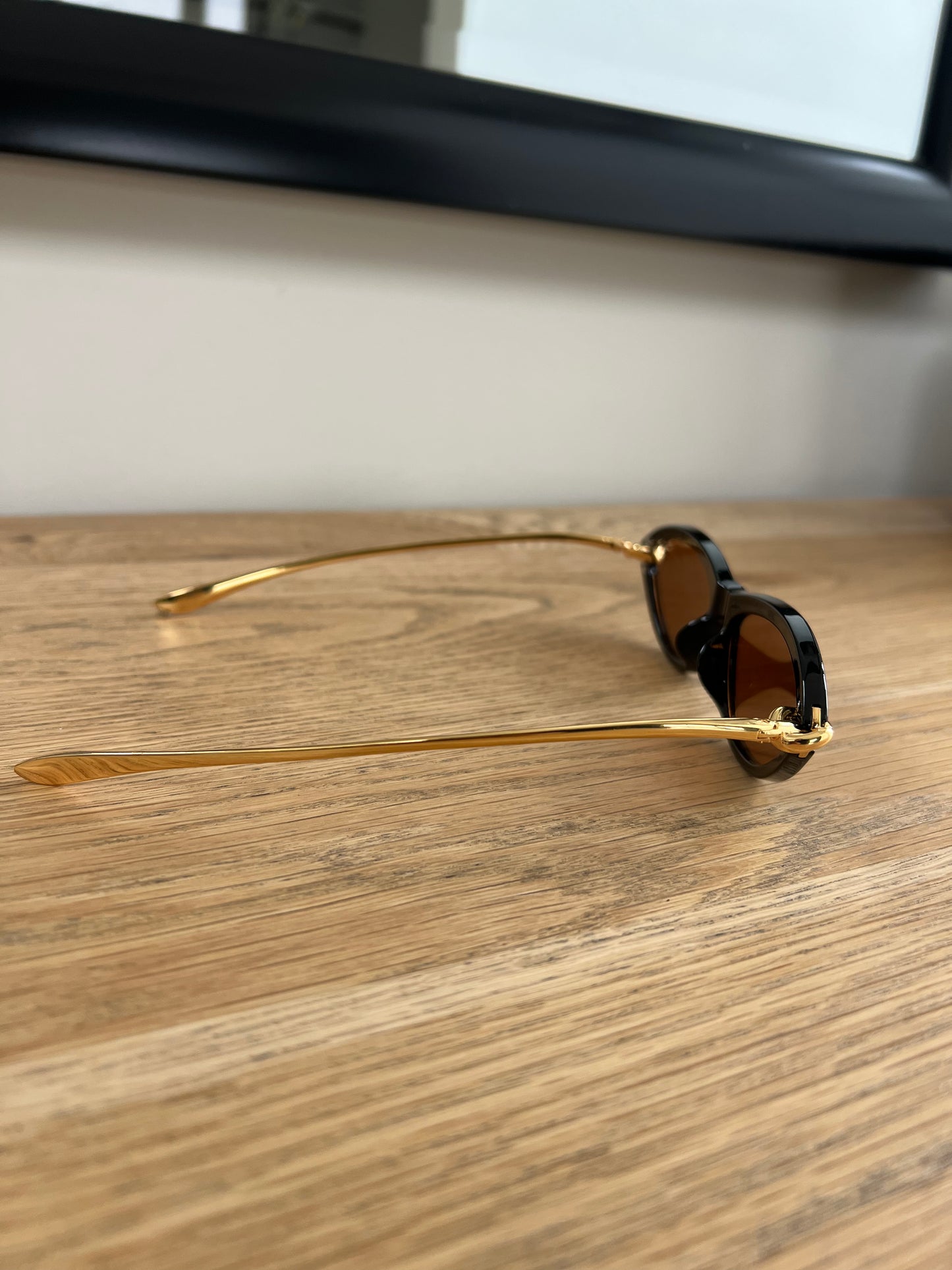 Side view of Black Oval Frame Sunglasses – gold accent retro design